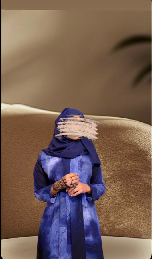 Oceanic elegance in every fold—this navy-blue abaya features a dreamy, wave-like print that flows beautifully with every step. Paired with a matching scarf for a seamless look.