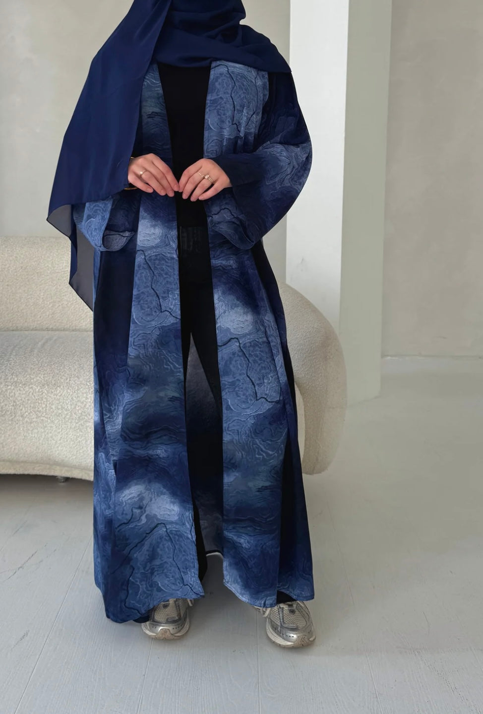 Oceanic elegance in every fold—this navy-blue abaya features a dreamy, wave-like print that flows beautifully with every step. Paired with a matching scarf for a seamless look.
